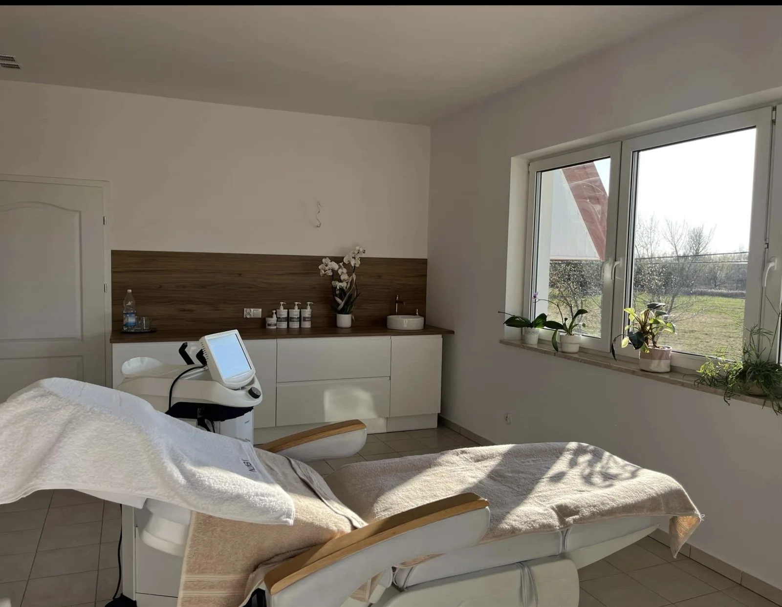 Gabinet zabiegowy, poranne słońce na leżance i drewniany blat